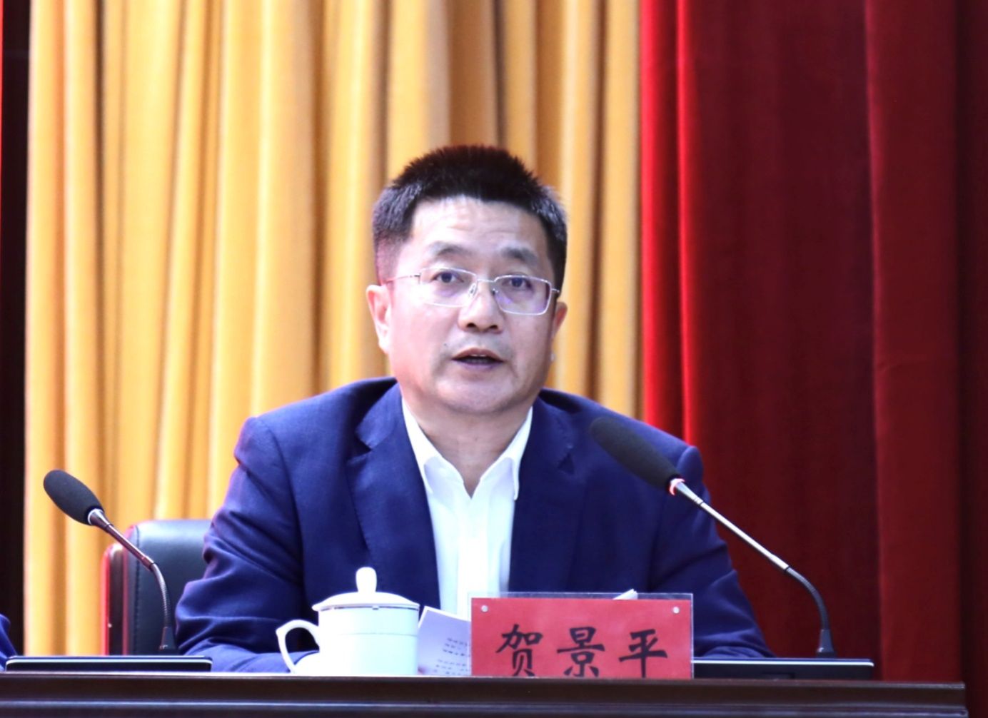 桌子前坐着穿西装的男人描述已自动生成 桌子前坐着穿西装的男人描述已自动生成